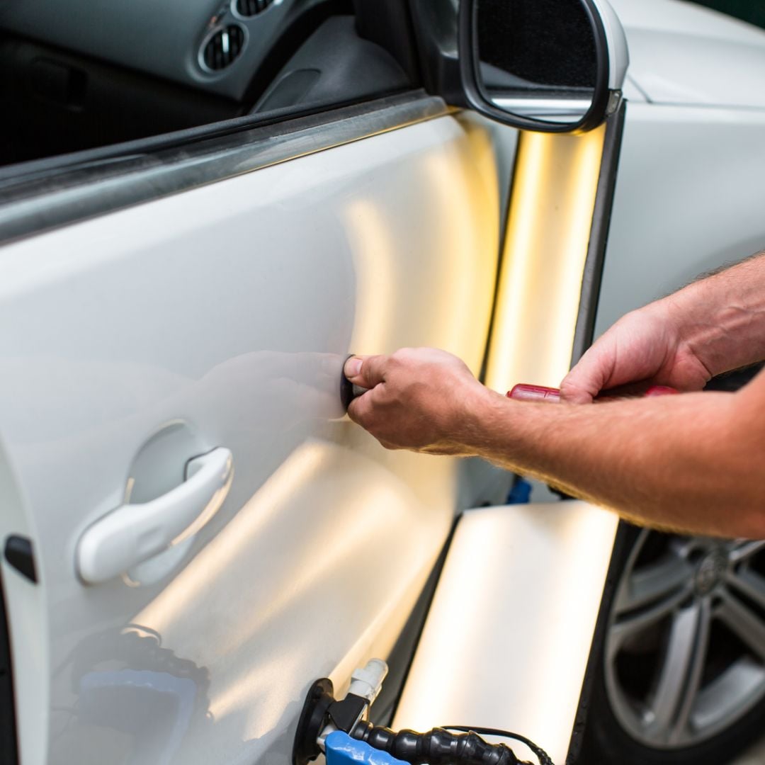 Technician performing affordable high-quality dent removal in Plano using paintless repair tools